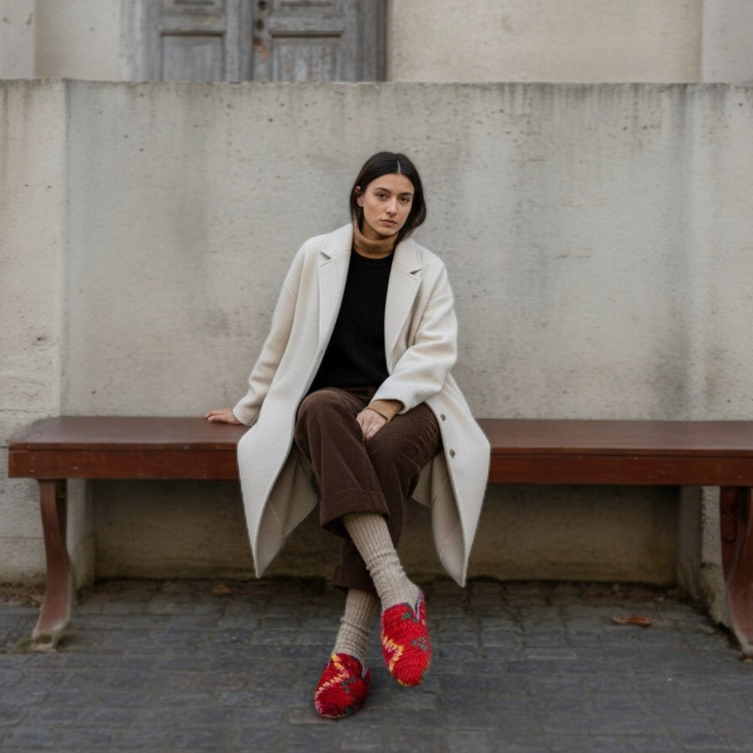 Mule Aisha de Leke’s destaca por su rojo intenso y su textura cálida, combinado con calcetines de lana, y un look street style minimalista.