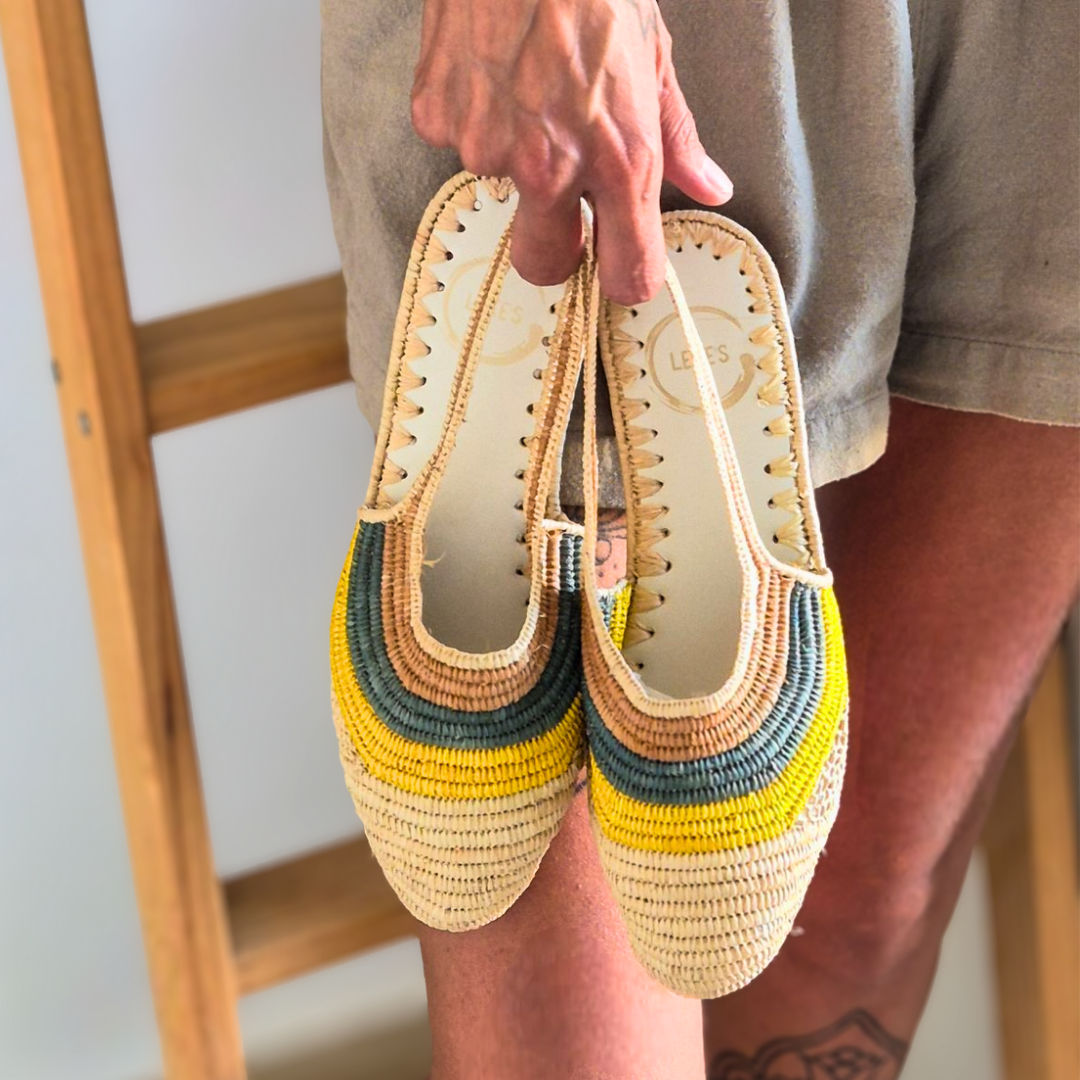 Sandalia Amel agarrada por las tiras traseras con un mono verde caqui